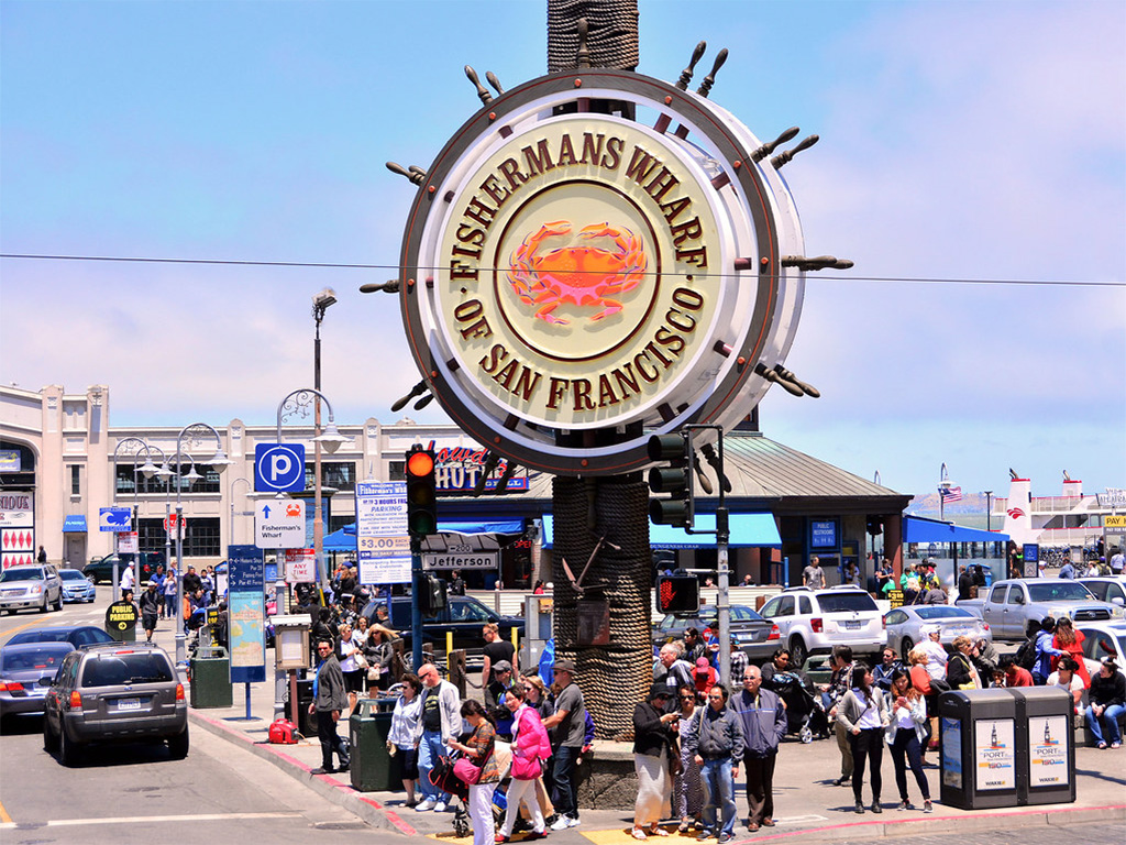 Fisherman's Wharf sign with busy corner in background